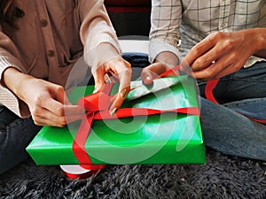 Man and Woman helping giftÃ¢â¬â¹ boxÃ¢â¬â¹ wrapping for Christmas New Year photo